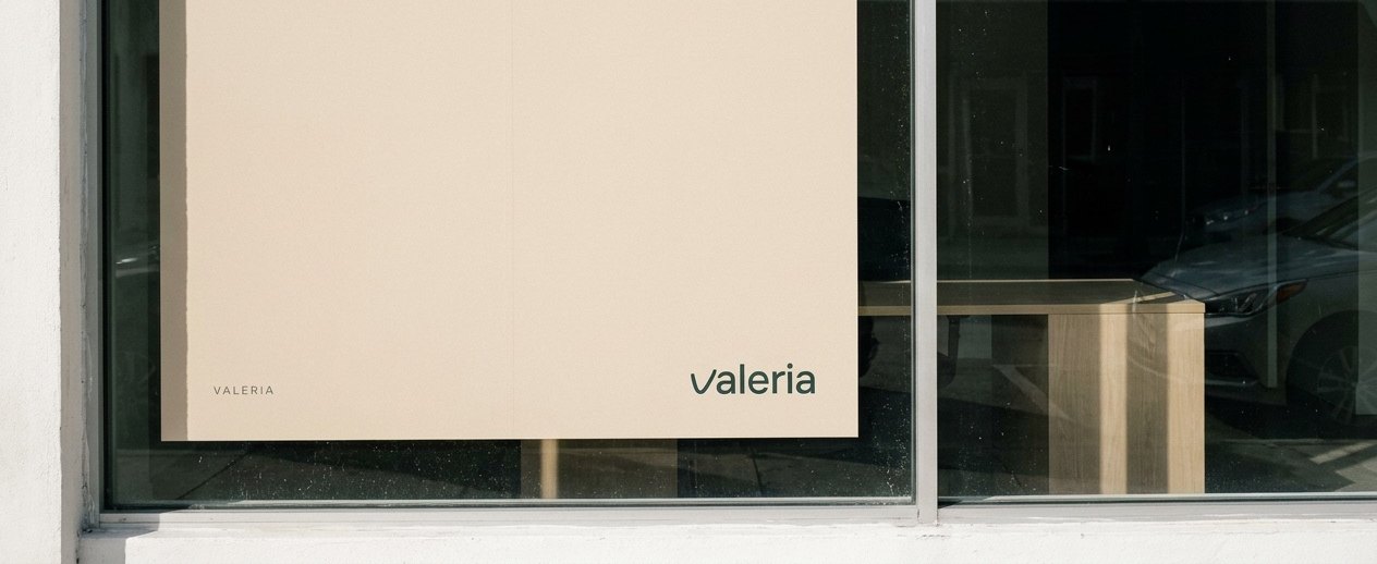 A VALERIA poster in a Miami shop window, the wordmark on Sand